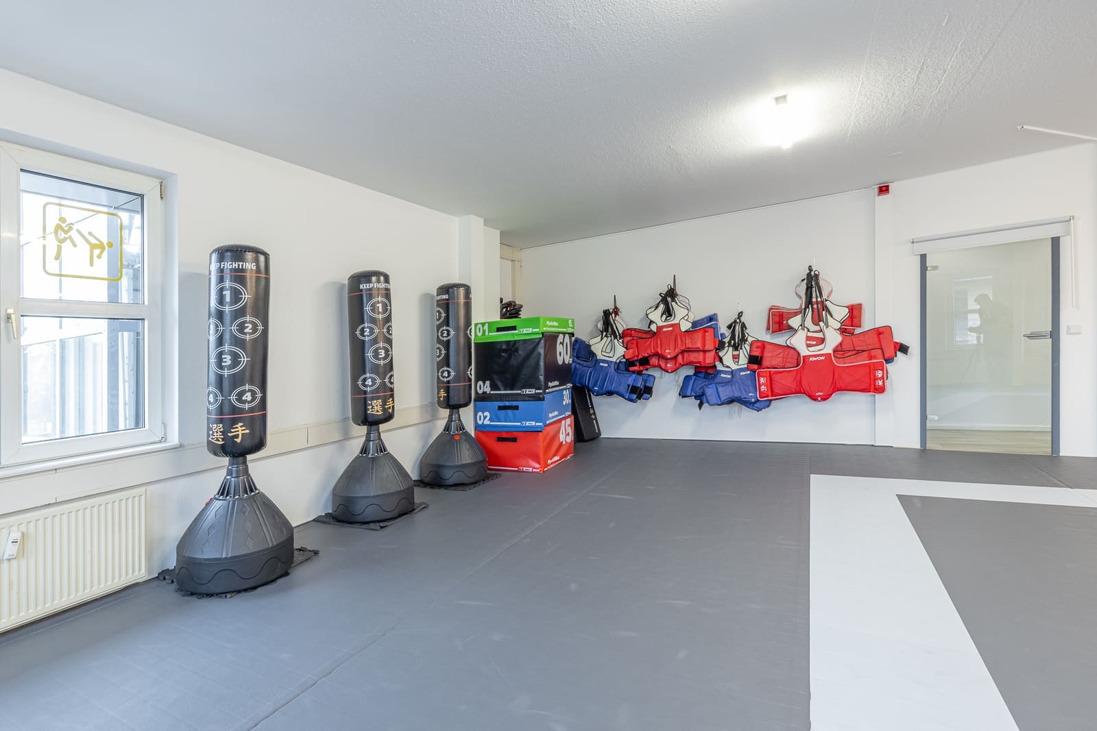 Bereich mit Standboxsäcken und Schutzausrüstung an der Wand