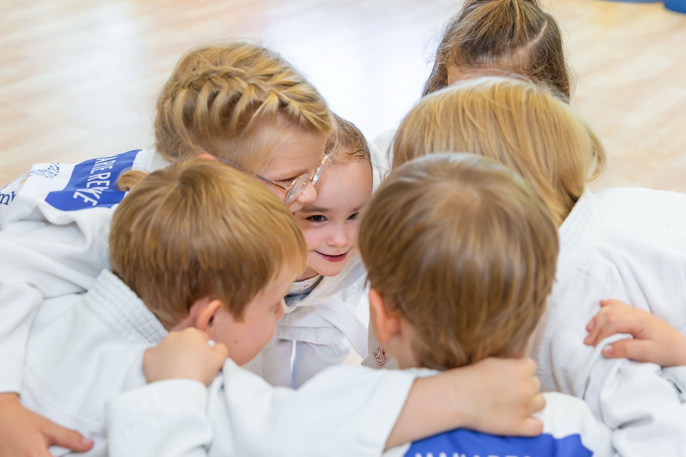 Kinder der Sportschule Senshu in einer Gruppenumarmung